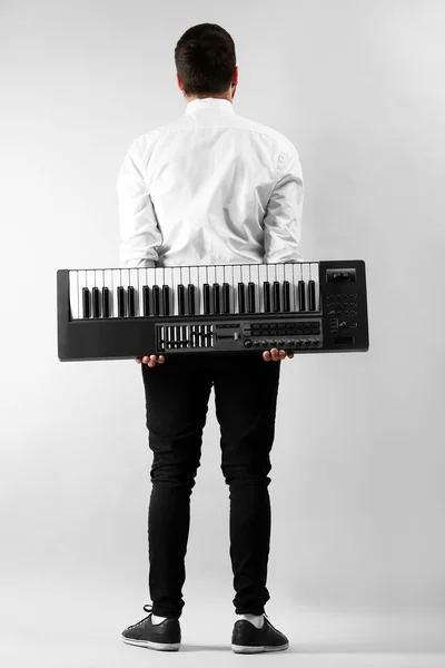 Man met synthesizer op muur achtergrond — Stockfoto