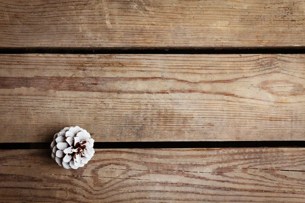 Bello sfondo semplice inverno con pigna su texture in legno — Foto Stock