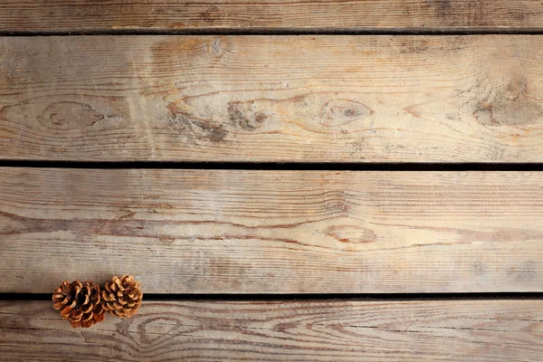 Krásné jednoduché zimní pozadí s šišky na dřevěné textury — Stock fotografie