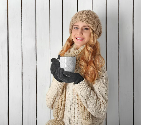 Retrato de invierno de una joven rubia hermosa con su ropa de abrigo de punto, con taza de bebida caliente — Foto de Stock