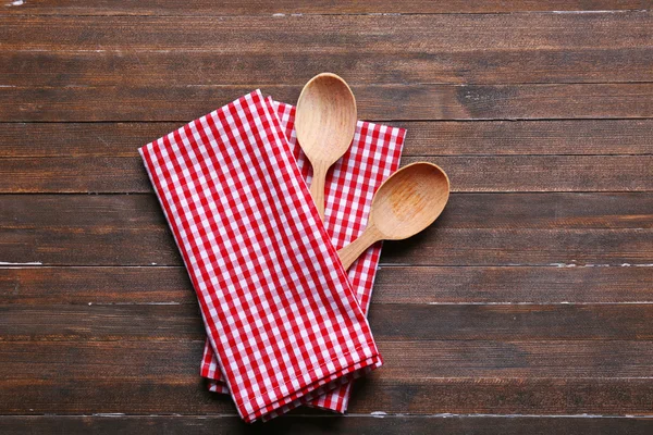 Checkered napkin and spoons on wooden background — Stock Photo, Image