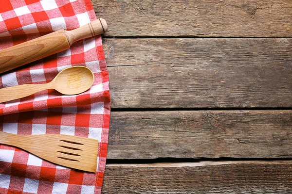 Geblokte servetten en bestek op houten achtergrond — Stockfoto