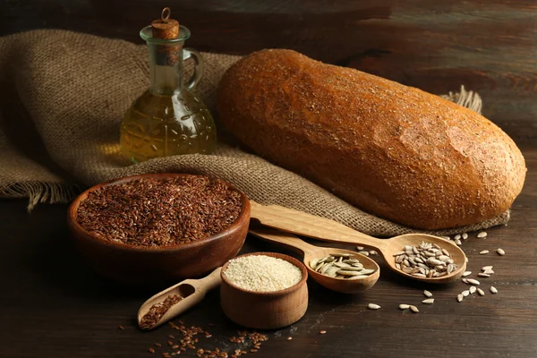 Semi vari con pane e olio su fondo tavola in legno, primo piano — Foto Stock