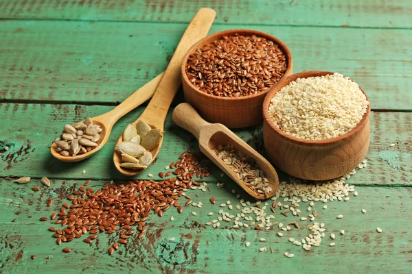 Various seeds on green wooden background, closeup — Stock Photo, Image