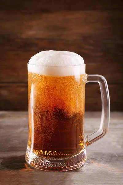 Glass mug of light beer on wooden table, close up — Stock Photo, Image