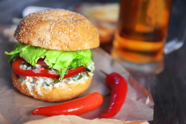 Hamburguesa grande sabrosa con chile sobre papel, de cerca — Foto de Stock