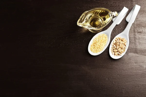 Graines de tournesol et de sésame à l'huile sur table en bois — Photo