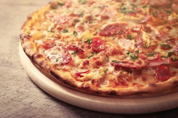 Pyszną pizzę na drewnianym stole, z bliska — Zdjęcie stockowe