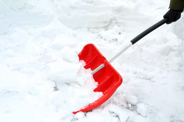 Concetto invernale. Mano donna con pala rossa per rimozione neve — Foto Stock