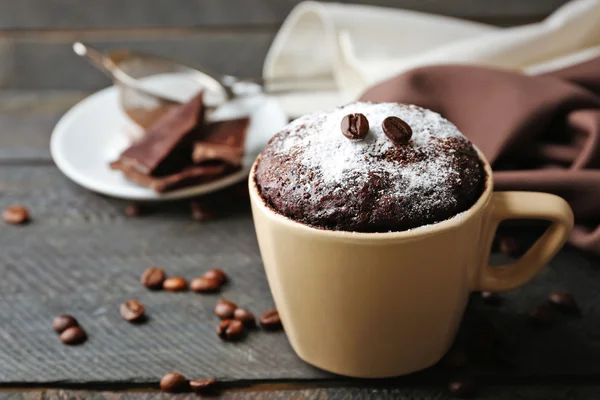 Bolo de fondant de chocolate na xícara em fundo de madeira — Fotografia de Stock