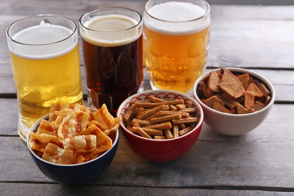 Olika typer av öl och snacks på träbord — Stockfoto