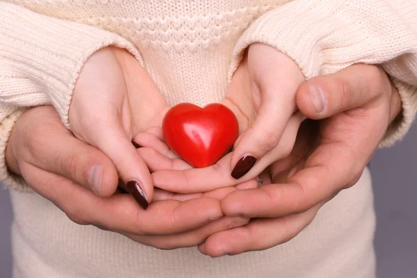 Ung par i kärlek håller rött hjärta — Stockfoto