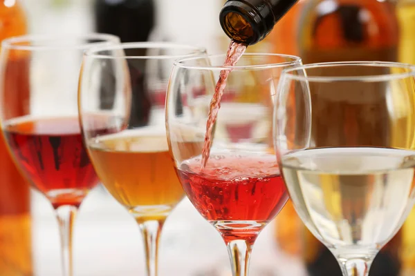 Red wine pouring into glasses, closeup — Stock Photo, Image