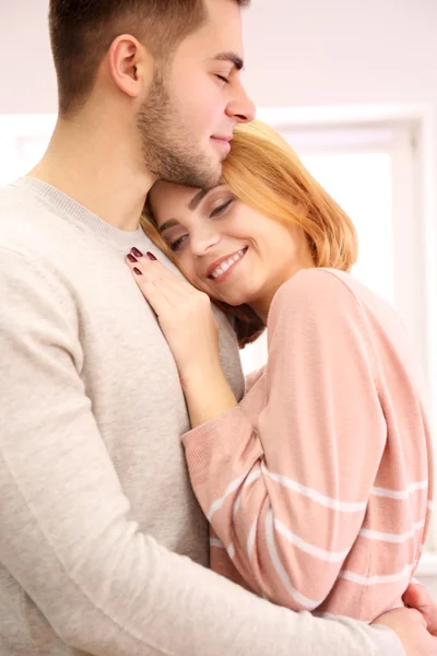 Young couple in love embracing beside the window — Stock Photo, Image