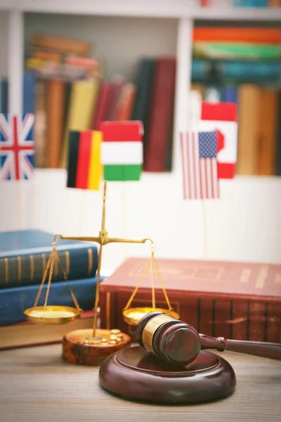 Gavel with justice scales and stack of books on wooden table — Stock Photo, Image