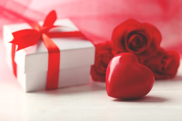 Caja de regalo, flores de rosas y corazones decorativos sobre fondo de madera claro Imágenes De Stock Sin Royalties Gratis