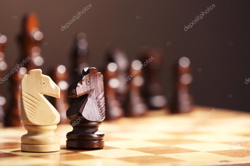 Premium Photo  Closeup of chess pieces on the chessboard under the lights  with a blurry background