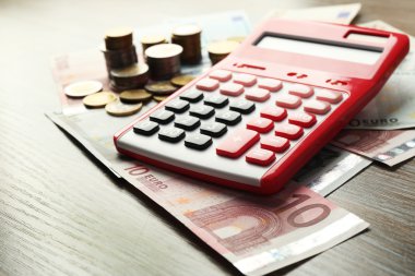 Para kavramı. Banknot ve ahşap masa üzerinde para ile kırmızı hesap makinesi