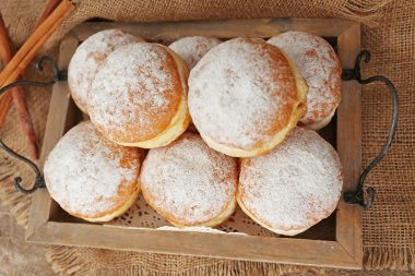 Lezzetli şekerli çörek içinde ahşap tepsi, üstten görünüm