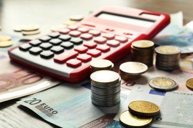 Para kavramı. Kırmızı hesap makinesi ile banknot ve madeni paralar, yakın çekim