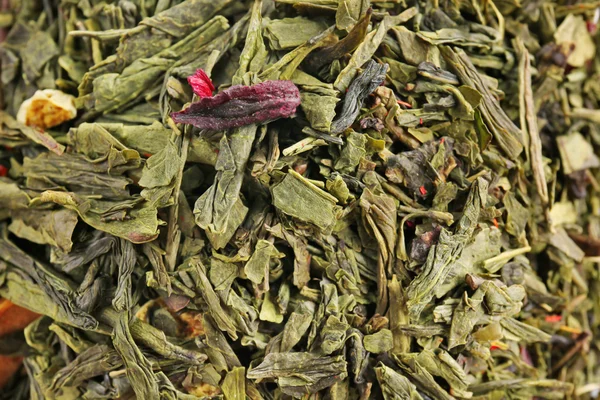 Chá seco com bagas, pedaços de frutas e pétalas de flores no fundo — Fotografia de Stock