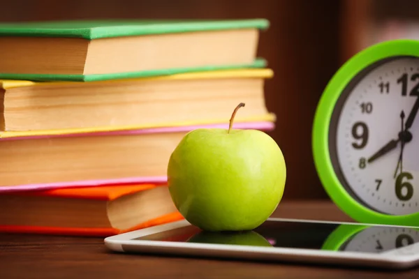 Composição com tablet, maçã e livros na mesa na sala — Fotografia de Stock