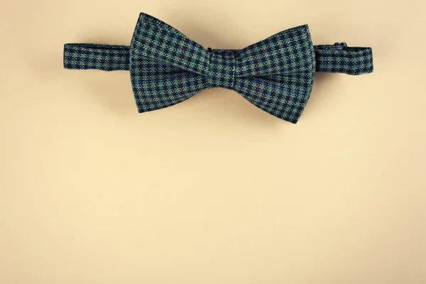 Green bow tie on beige background — Stock Photo, Image