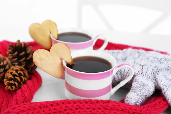 Heart shape cookie on cup of coffee with red knitted scarf closeup — Stock Photo, Image