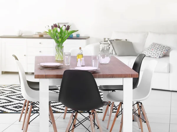 Sala de estar moderna. Set de muebles con mesa y sillas. Ramo de hermosos tulipanes morados en la mesa — Foto de Stock