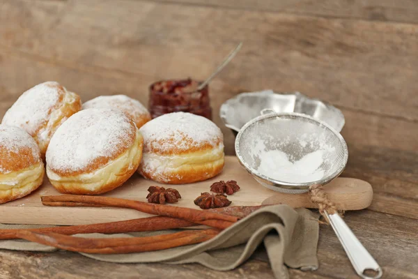 Delicious sugary donuts with spices on wooden background — Stock Photo, Image