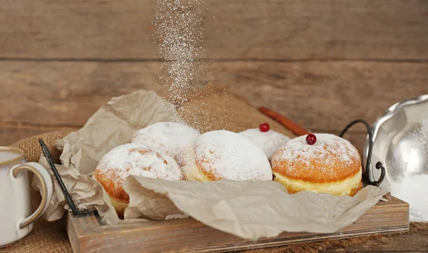 Deliciosos donuts açucarados com groselha vermelha em fundo de madeira — Fotografia de Stock