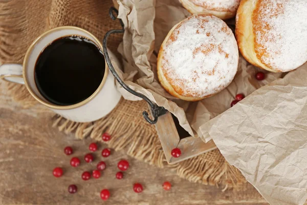 Deliciosas rosquillas azucaradas con grosella roja en bandeja de madera con pergamino de primer plano —  Fotos de Stock