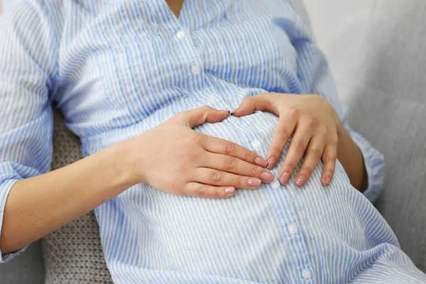 Pregnant woman resting on sofa in the room — Stock Photo, Image