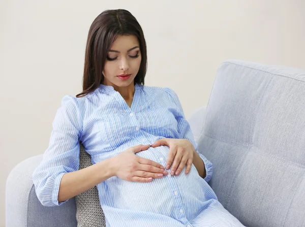 Donna incinta che riposa sul divano nella stanza — Foto Stock