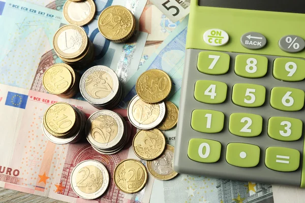 Концепція грошей. Зелений калькулятор з банкнотами і монетами, крупним планом — стокове фото