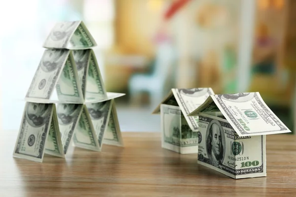 Piramide di soldi con case di soldi su tavolo di legno, vicino — Foto Stock