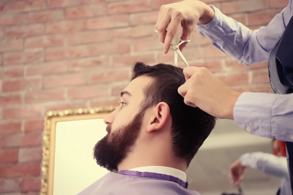 hairdresser making stylish man haircut