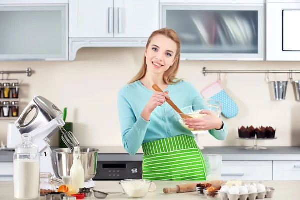 Young woman mixing dough in a bowl — Stock Photo, Image