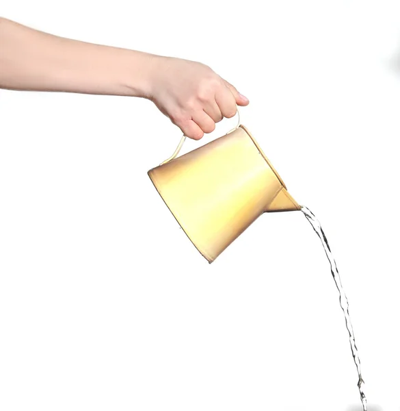 Ženská ruka nalití vody z bílé plastové nádobky, izolovaných na bílém — Stock fotografie