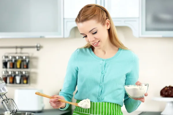 Молода жінка додає борошно, щоб зробити тісто — стокове фото