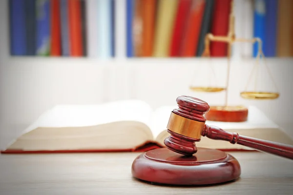 Gavel com escalas de justiça e livro aberto sobre mesa de madeira, close-up Imagem De Stock