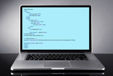 Programlama kodu üstünde laptop 
