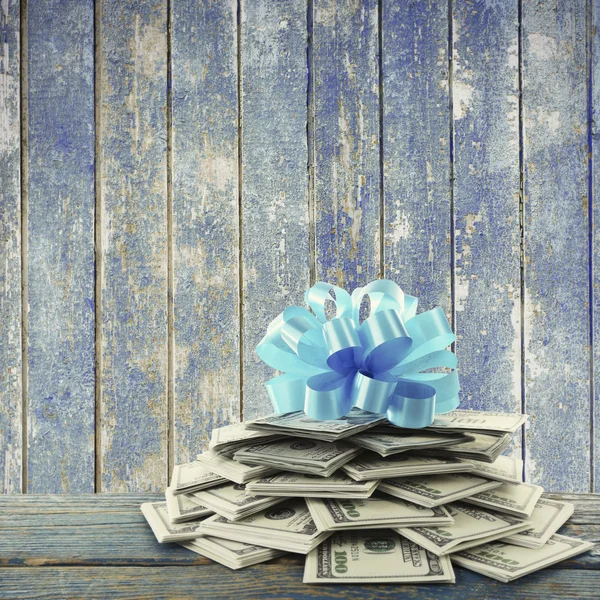 Hög med dollar med rosett som gåva — Stockfoto