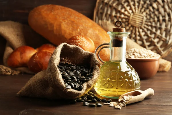 Slunečnicová semena, chléb a olej na dřevěný stůl pozadí, záběr — Stock fotografie