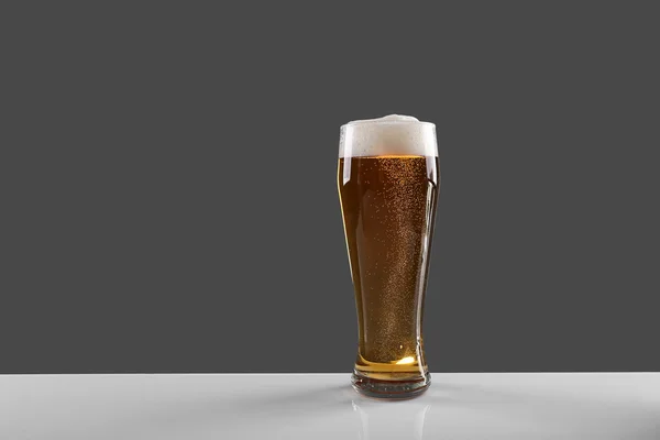 Vaso de cerveza lager sobre fondo gris — Foto de Stock