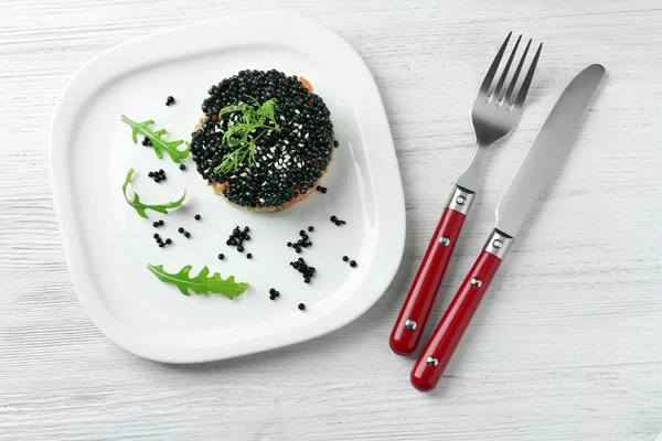 Delicious salmon tartare with black caviar on white plate — Stock Photo, Image