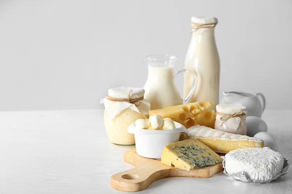 Taze süt ürünler ve beyaz arka plan üzerinde ahşap tablo ayarlama — Stok fotoğraf