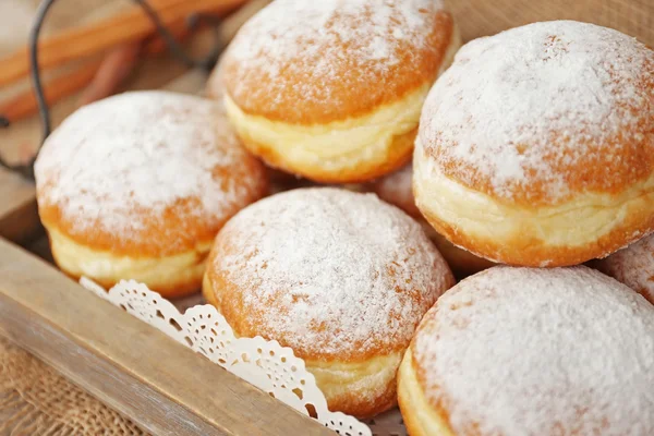 Deliciosas rosquillas azucaradas en bandeja de madera — Foto de Stock