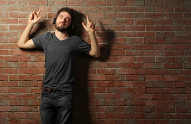 Kulaklıkla müzik dinleyen genç adam. 