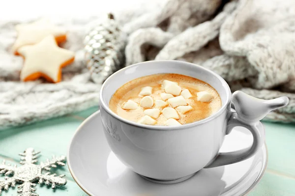 Tazza di cacao caldo con marshmallow, biscotti e sciarpa calda sul tavolo blu — Foto Stock